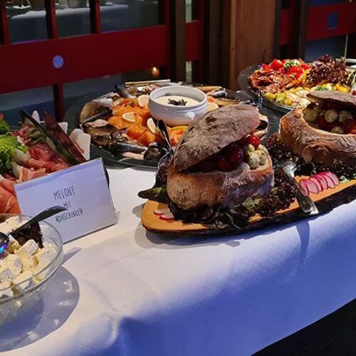 Kaltes Büfett mit Melonenschiffchen, Brot und weiteren Speisen
