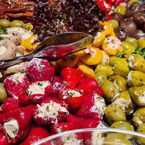 Antipastiplatte mit Oliven, gefüllter Paprika, gefüllten Champignons und getrockneten Tomaten