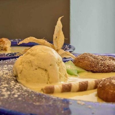 Eine Kugel Vanilleeis, serviert mit Vanillesoße und Keksen.