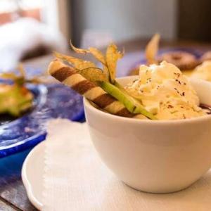 Impressionen | Dessert mit Sahne, Sternfrucht und Keksröllchen garniert